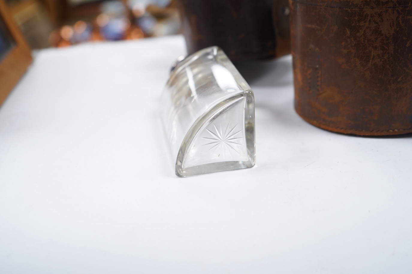 A cased set of four Edwardian silver mounted glass travelling scent bottles, with engraved monogram, George Bedingham, London, 1901, housed in a circular leather carrying case, bottles 14.5cm. Condition - fair to good an